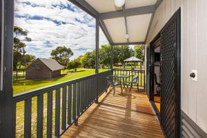 a balcony with a table and a view of a barn at Echo Holiday Parks - Naracoorte in Naracoorte