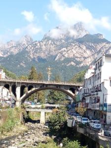 uma ponte sobre um rio com uma montanha ao fundo em Huang Mountain Wangfeng Hotel em Montanhas Huangshan