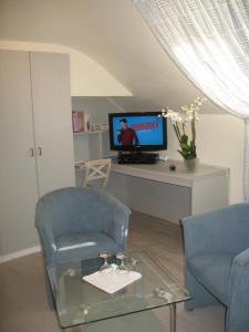 a living room with two chairs and a television at B&Logies De Duinroos Koksijde in Koksijde