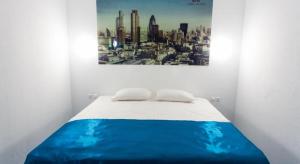 1 cama en una habitación con una foto en la pared en Global Sky Apartments, en Novosibirsk