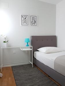 a white bedroom with a bed and a blue lamp at Villa LeANN in Okrug Donji +24 photos