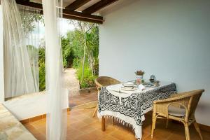 ein Esszimmer mit einem Tisch, Stühlen und einem Fenster in der Unterkunft Apartamentos Es Carnatge - Formentera Vacaciones in Playa Migjorn