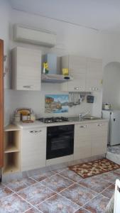 uma cozinha com armários brancos e um forno com placa de fogão em Francesca House em Atrani