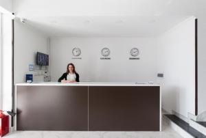 a woman sitting at a counter in an office at Аtria Hotel in Adler