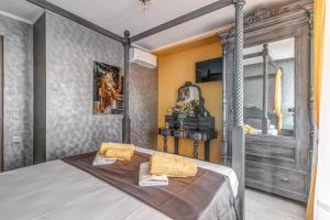 a bedroom with a canopy bed with two yellow pillows at Eos Aurora Suite in Corfu Town