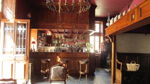 - un bar avec tabourets de bar et une étagère avec alcool dans l'établissement Chateau d'Urbilhac, à Lamastre