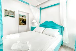 - une chambre dotée d'un lit bleu et blanc avec deux oreillers dans l'établissement Belone Suite, à Corfou
