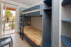 a bunk bed in a room with a window at Village Vacances Passion La Grande Bastide in Le Lavandou