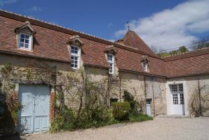 an old stone house with white doors and a roof at Château de Fontnoble in Biozat
