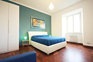 罗马Rome Aparts的卧室里有一张床，上面铺着蓝色毯子