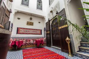 um quarto com um banco e um tapete vermelho no chão em Riad Taha em Fez