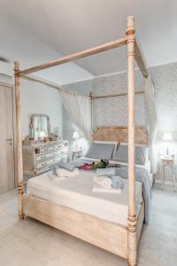 una camera con un grande letto con struttura in legno di Papalina Suite a Città di Corfù