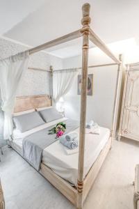 a bedroom with a canopy bed with flowers on it at Papalina Suite in Corfu Town