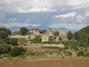 a group of houses on a hill with mountains in the background at Casa Rural Urbe in Campodarbe