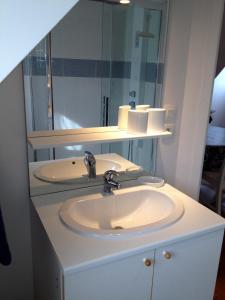 bagno con lavandino bianco e specchio di Appartements et gîte Les Hauts de Sophia a Trouville-sur-Mer