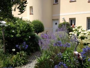 un giardino di fiori di fronte a un edificio di Appartements et gîte Les Hauts de Sophia a Trouville-sur-Mer