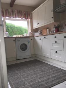 a kitchen with a washing machine and a window at Fir Tree Cottage in Chester