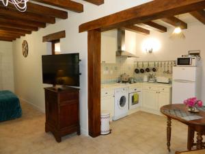 uma cozinha com uma televisão, uma mesa e um fogão em Gite de Cray em Lussault-sur-Loire