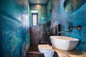 a blue bathroom with a sink and a toilet at Keros Blue - Luxury in Wilderness in Kalliópi