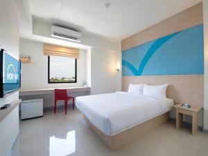 Säng eller sängar i ett rum på Hop Inn Lampang