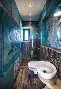 a bathroom with blue walls and a sink and a toilet at Keros Blue - Luxury in Wilderness in Kalliópi