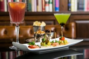 a plate of food on a table with two drinks at Hotel Montefiore in Tel Aviv