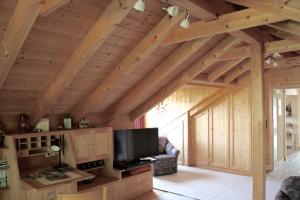 a living room with wooden ceilings and a flat screen tv at Haus Farbenklang in Zwiesel