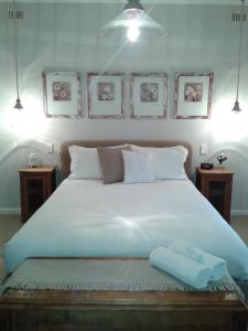 a bedroom with a large white bed with two tables at Casa Rossa - Barossa in Lyndoch