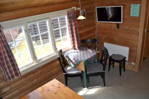 Zimmer mit einem Tisch, Stühlen und einem TV in der Unterkunft Vekve Hyttetun in Oppdal