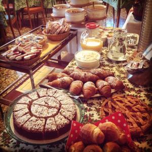 una tavola piena di diversi tipi di prodotti da forno e torte di Hotel Villa Patrizia a Cutigliano