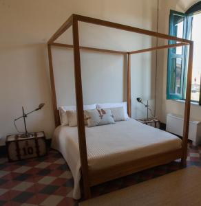 a bedroom with a canopy bed and a checkered floor at Le stanze del Capostazione in Bagheria