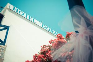a street sign on the side of a building with flowers at Dora's Studios & Apartments in Megas Gialos - Nites