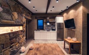 a kitchen with a stone wall and a refrigerator at Keros Blue - Luxury in Wilderness in Kalliópi