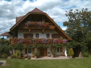 a house with a balcony with flowers on it at Gasthof Ferm in Schiefling am See
