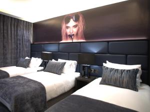 um quarto de hotel com duas camas e uma pintura de uma mulher em The Residence Hotel em Galway