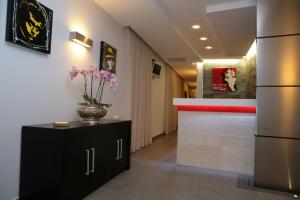 a lobby with a bar with a vase of flowers at Hotel Visagi in Pompei