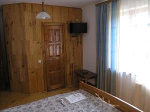 ヤレムチャにあるSadyba Bilya Richkyのベッドルーム1室(ベッド1台付)、木製のドア