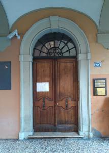 ボローニャにあるIl Tiro Roomsの木製の扉付きの建物の入口