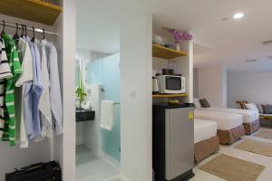a room with a closet and a bedroom with a bed at Sabai Sathorn Service Apartment in Bangkok +159 photos