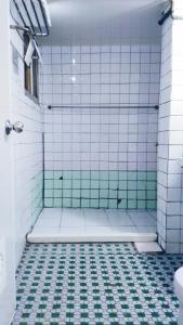 a bathroom with a shower with green and white tiles at Chia Rong Hostel in Taipei