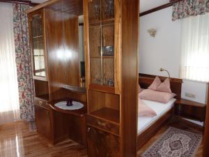 1 dormitorio con 1 cama y armario de madera en Villa Rose, en Sankt Kanzian
