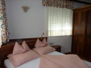 Un dormitorio con una cama con almohadas rosas. en Villa Rose en Sankt Kanzian