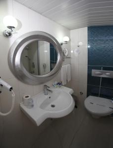 uma casa de banho com um lavatório, um espelho e um WC. em Cender Hotel em Antalya