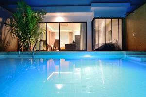 una gran piscina en un edificio con una casa en Pumeria Resort Phuket - SHA Plus, en Bang Tao Beach