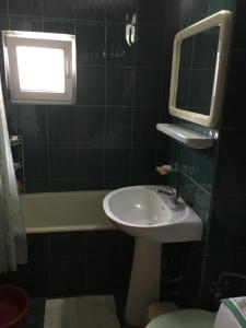 y baño con lavabo, espejo y bañera. en Apartament Aqua en Călimăneşti