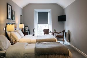 a hotel room with two beds and a couch at Haddington House in Dun Laoghaire