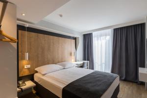 a hotel room with a bed and a large window at M Hotel in Ljubljana