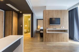 a living room with a tv and a bedroom at M Hotel in Ljubljana
