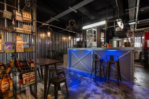 a bar with blue paint on the floor and stools at 和平公獄監獄文旅 近東大門夜市 Peace Prison Cafe Inn in Hualien City