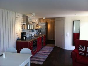 a kitchen with red cabinets and a red stove at Farbror Alfreds Hönshus Sjöutsikt in Köpingsvik